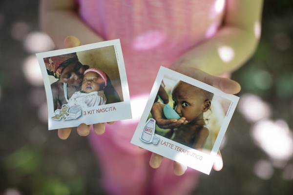 bambina mostra le cartoline di auguri da regalare kit nascita e latte terapeutico