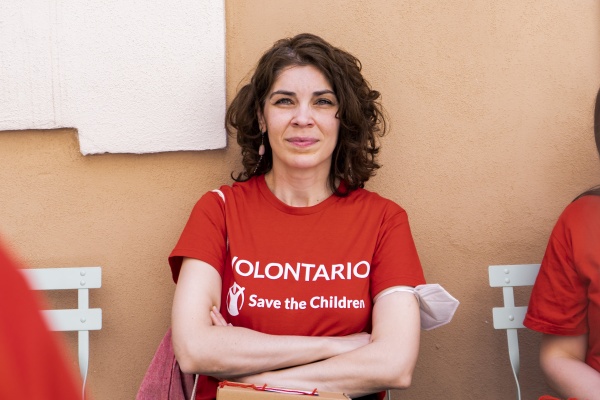 ragazza volontaria con maglietta save the children che posa con mani incrociate sul petto