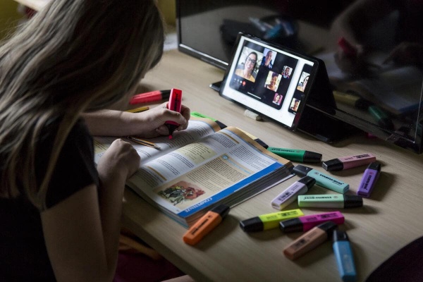 ragazzina con libro mentre studia online con il tablet 
