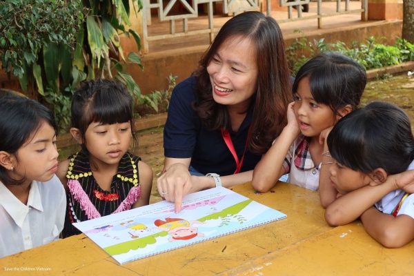  Bambini e operatrice Save the children in Vietnam mentre studiano 
