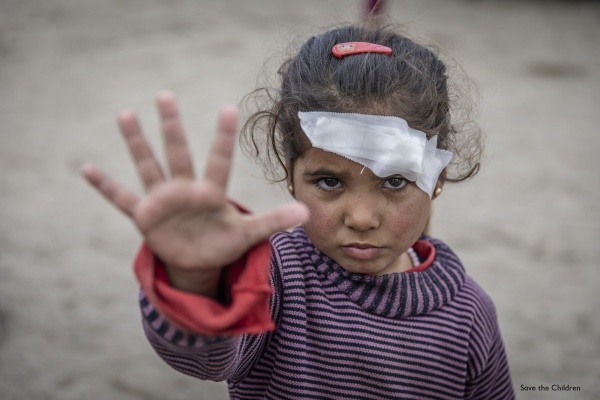 bambina in primo piano con fascia medica sul capo con mano aperta a segno di stop