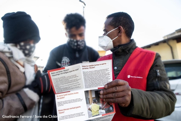 un operatore di save the children Italia fornisce alcune info a due persone