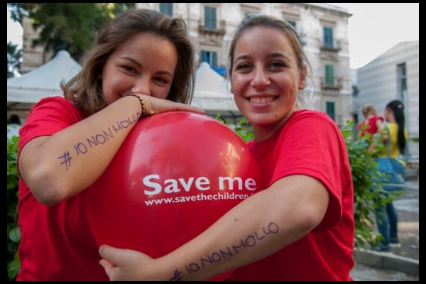 ragazze volontarie sorridenti che abbracciano un palloncino 