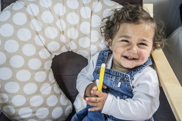 Bambina sorridente con un pennello giallo in mano