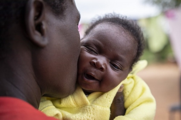 mamma nera che bacia la sua bimba neonata sulla guancia
