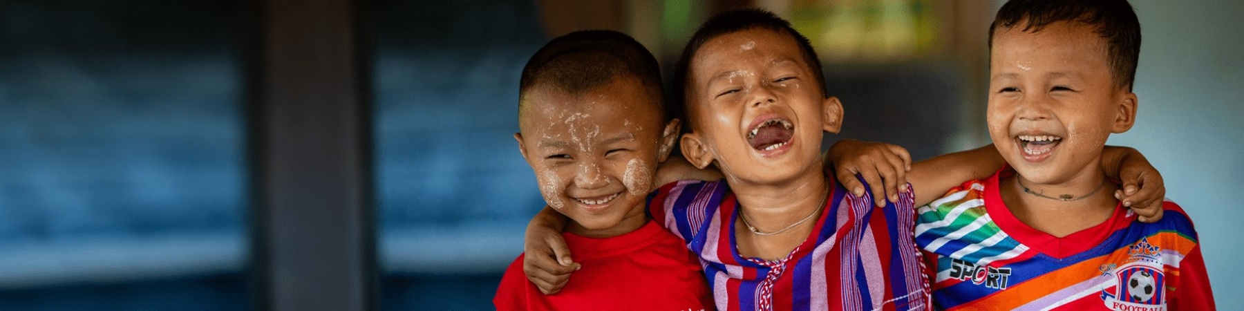 3 bambini sorridenti che si abbracciano