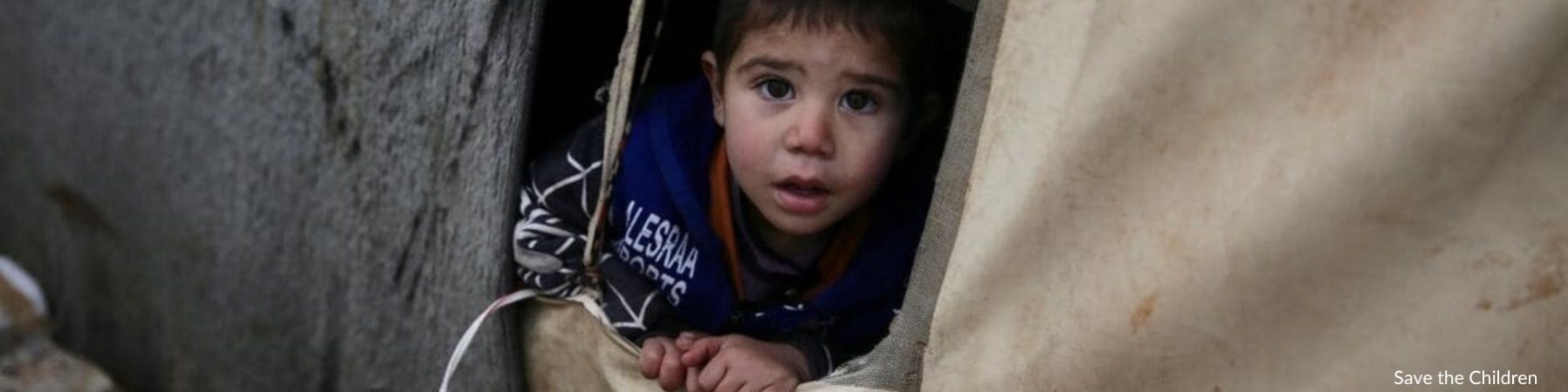 Karim bambino siriano che fuoriesce da tenda del campo profughi 