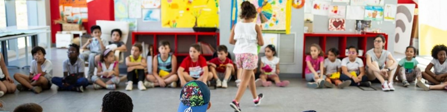 bambini seduti in cerchio per svolgere delle attività di gioco