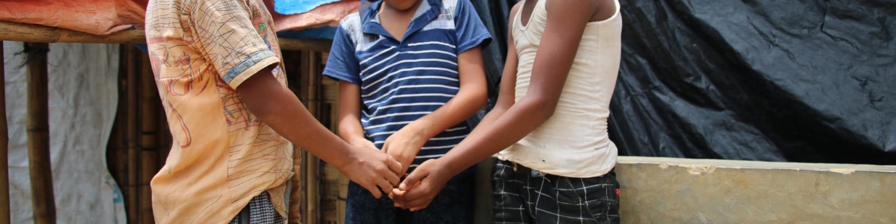 Tre bambini in cerchio si danno la mano