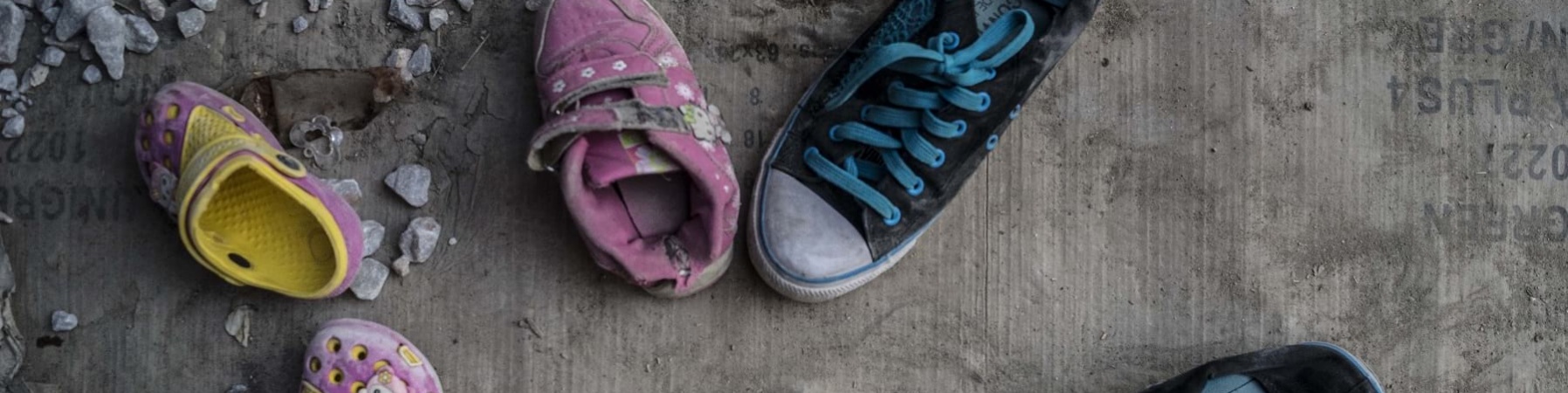 Scarpe vecchie di bambini abbandonate sul terreno