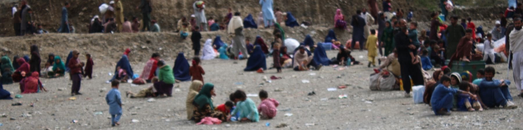 bambini e famiglie seduti a terra tornati dal pakistan in afghanistan 