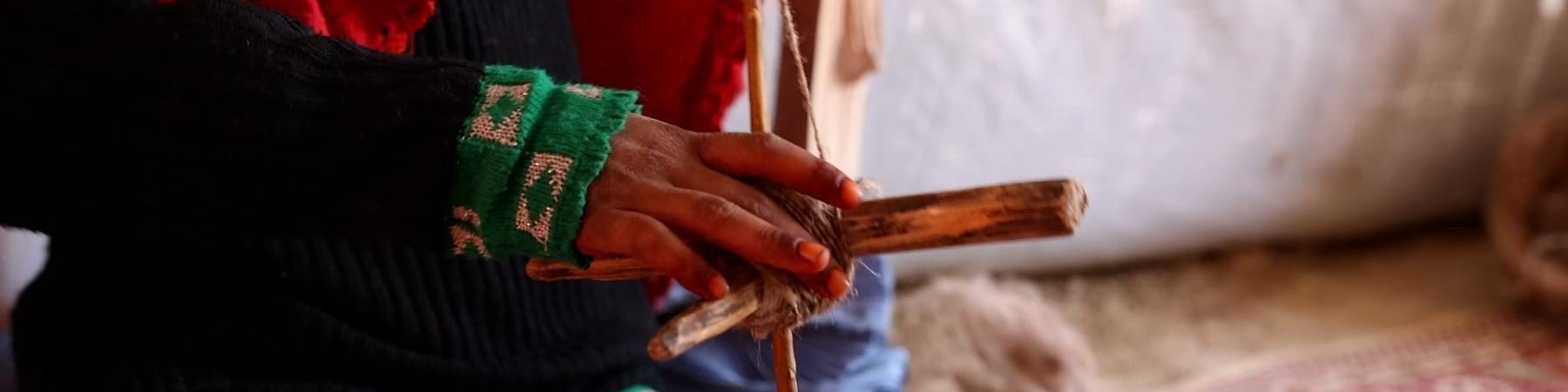 primo piano mani di una bambina che ha in mano un telaio