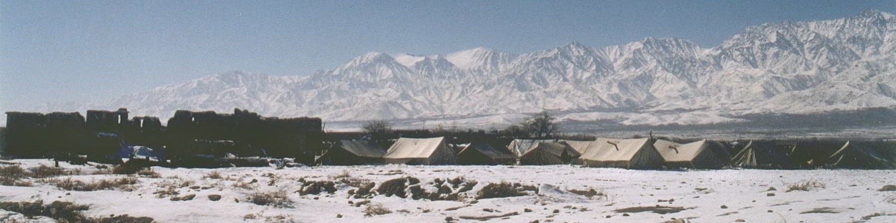 tende di un campo profughi su un campo di neve ai piedi di alte montagne innevate in afghanistan