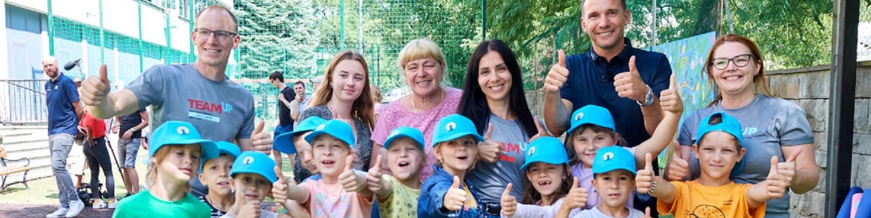 Andriy Shevchenko posa con pollice in su con i bambini fuggiti dalla guerra in Ucraina