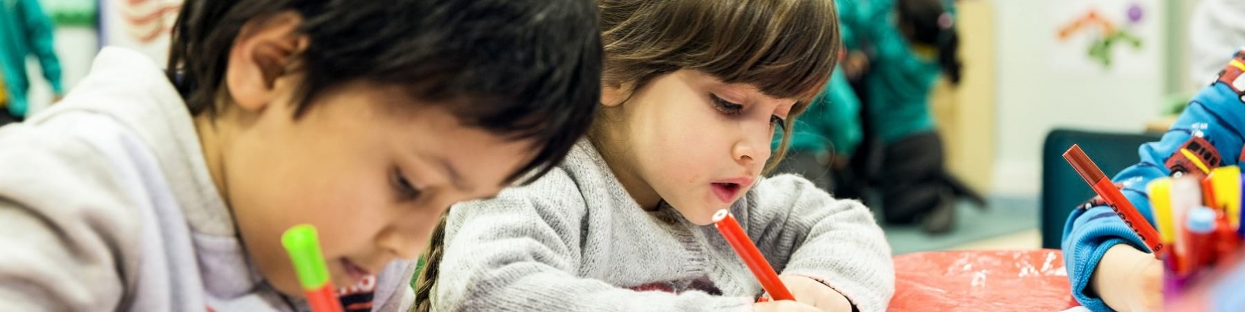 due bambini di 5 anni disegnano con matite seduti a tavolino