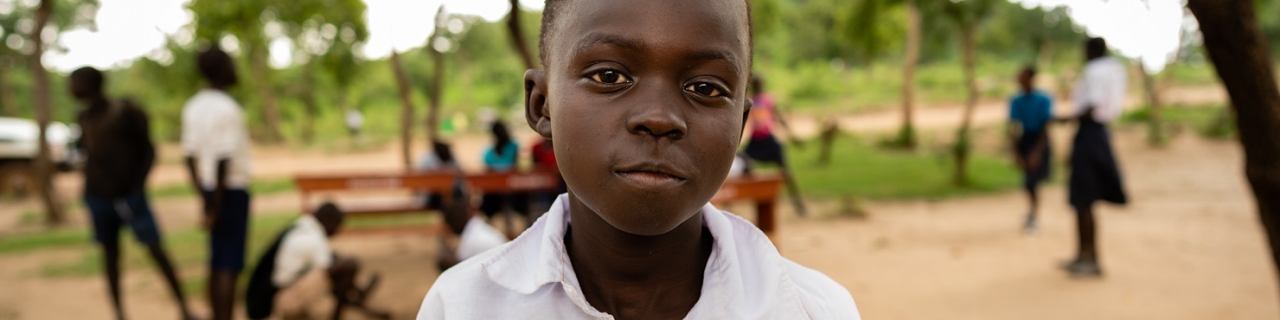 Bambino africano con divisa della scuola in un campo rifugiati