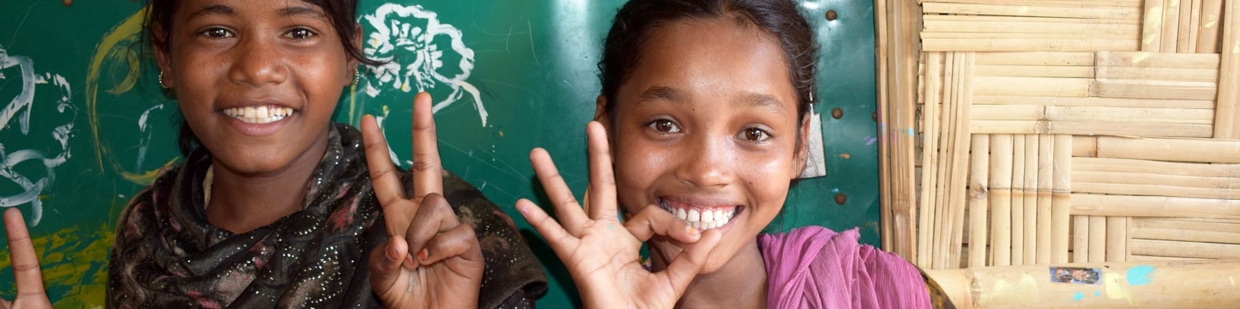 Due bambine in posa sorridono e fanno il gesto di ok