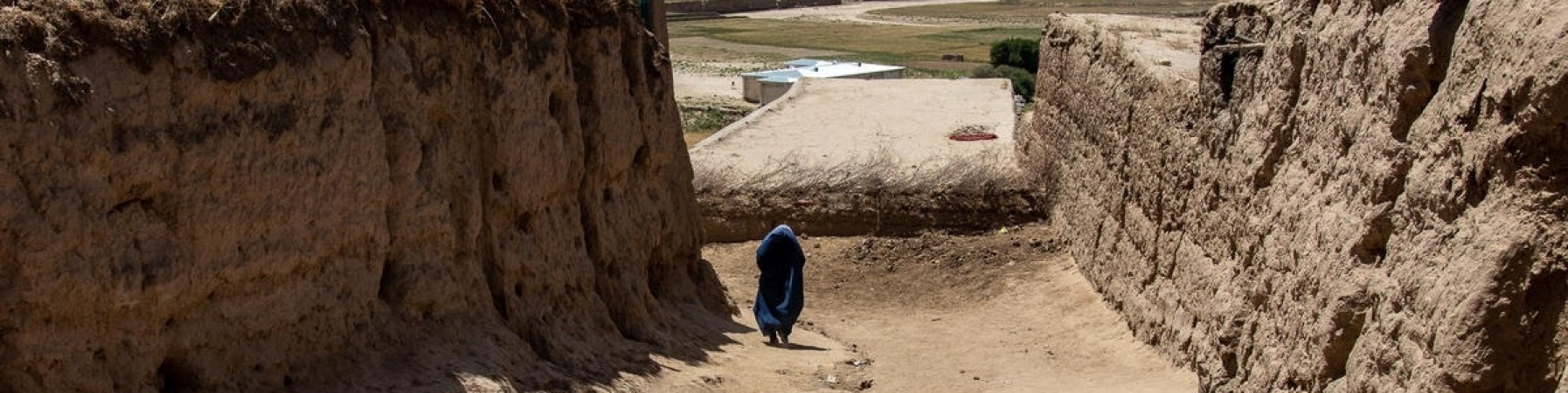 ragazza con velo cammina tra le mura della città iraniana