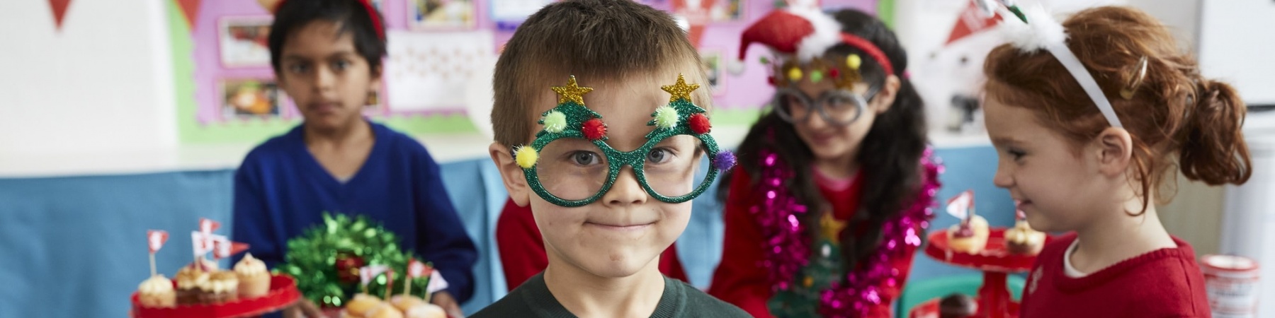 4 bambini vestiti per il Christmas Jumper Day a scuola