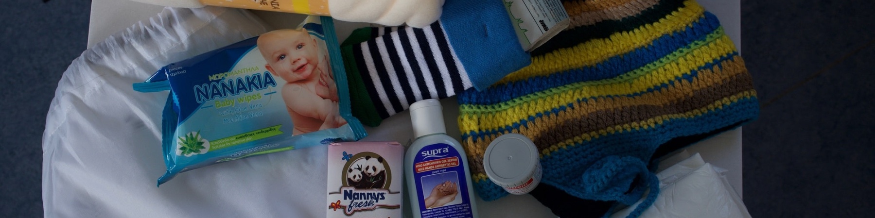 kit per genitori e neonato dove ci sono salviette, coperte, calzine, pannolini etc