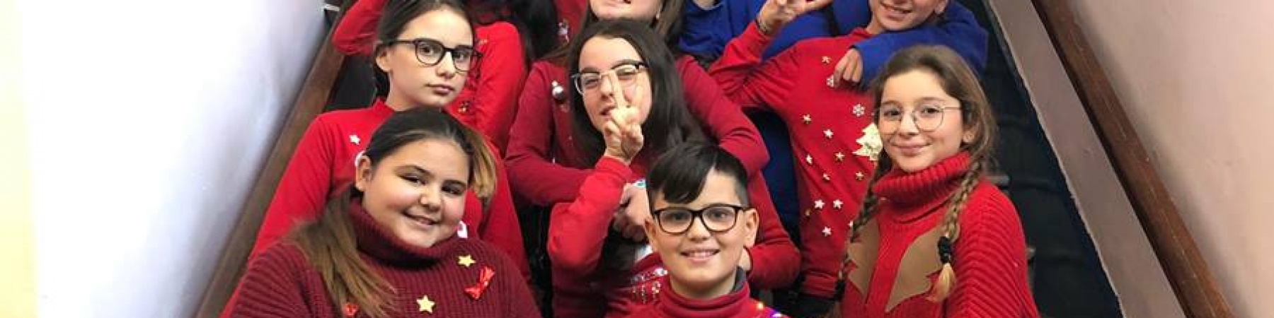 bambini sulle scale che indossano maglioni rossi