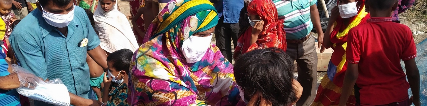 gruppo di persone di origine indiana durante una consegna di mascherine per proteggersi dal covid-19
