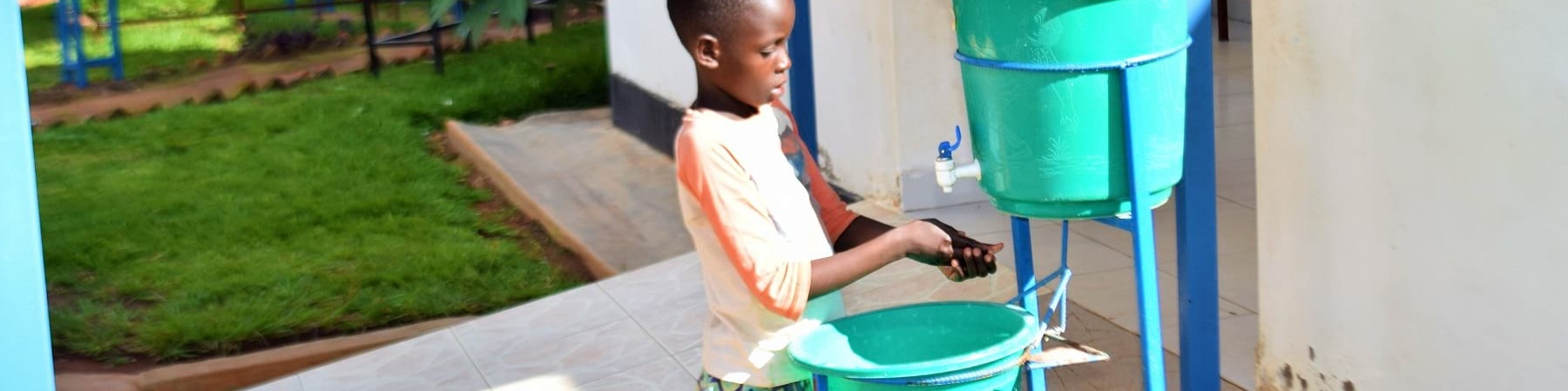 bambina del Rwanda lava le mani con rubinetto portatile