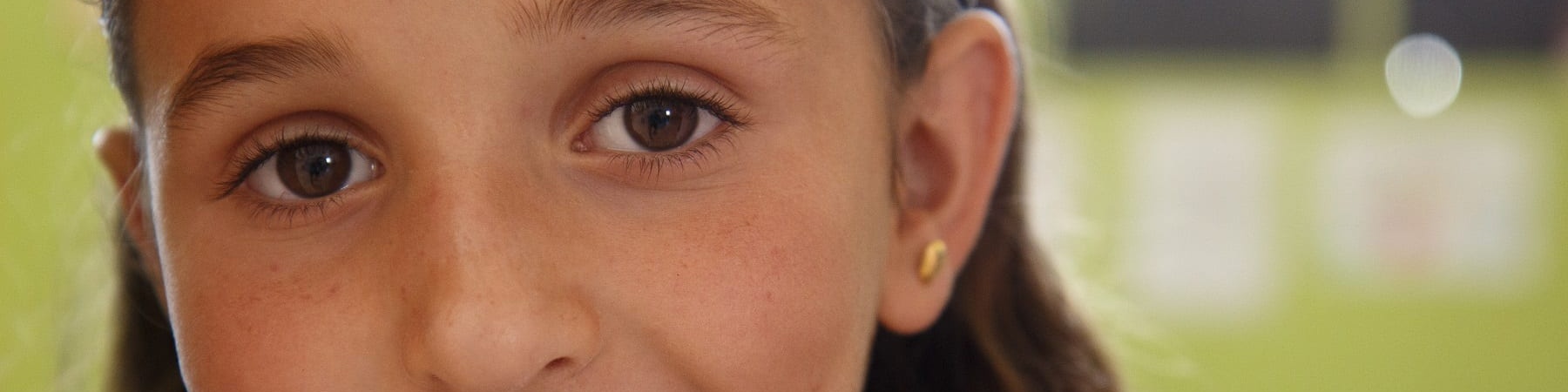 Primo piano di una bambina bionda sorridente che guarda in camera