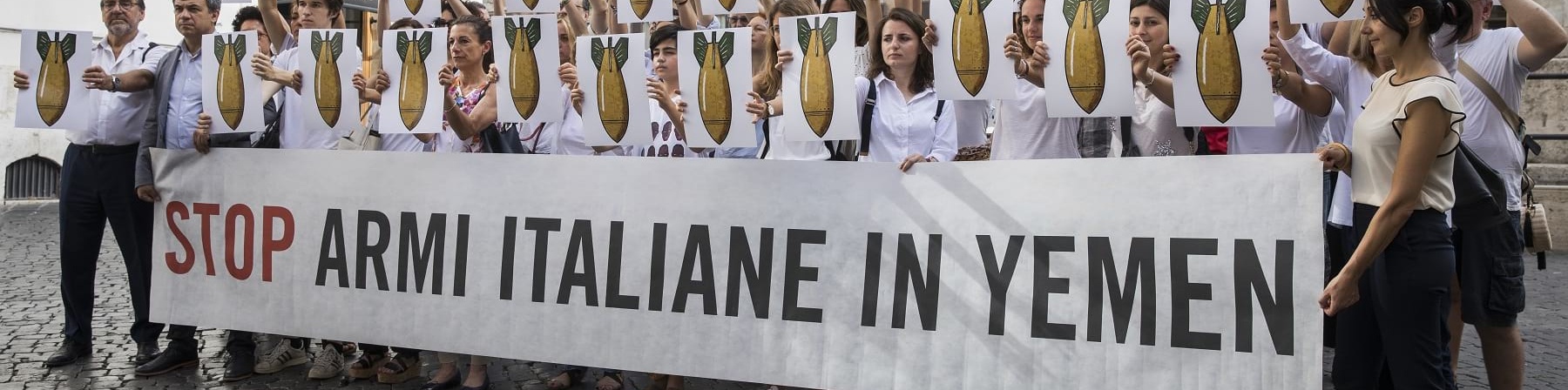 Gruppo di persone davanti a Monte Citorio tengono uno striscione con la scritta "Stop armi italiane in Yemen"