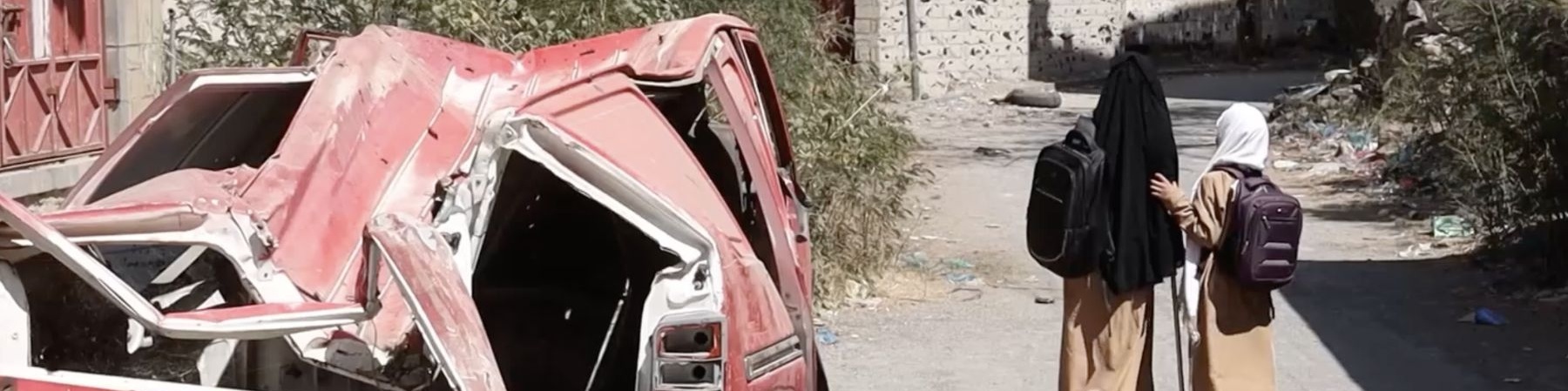 bambine in Yemen che camminano per strada a sinistra macchina distrutta