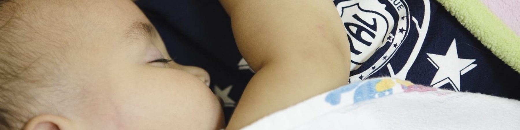 neonato di spalle steso e abbracciato alla madre