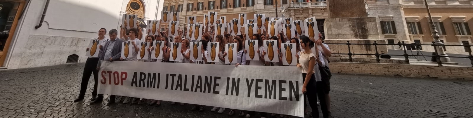 piazza Montecitorio a Roma flash mob con persone davanti a striscione per chiedere lo stop allesportazione di armi in Yemen