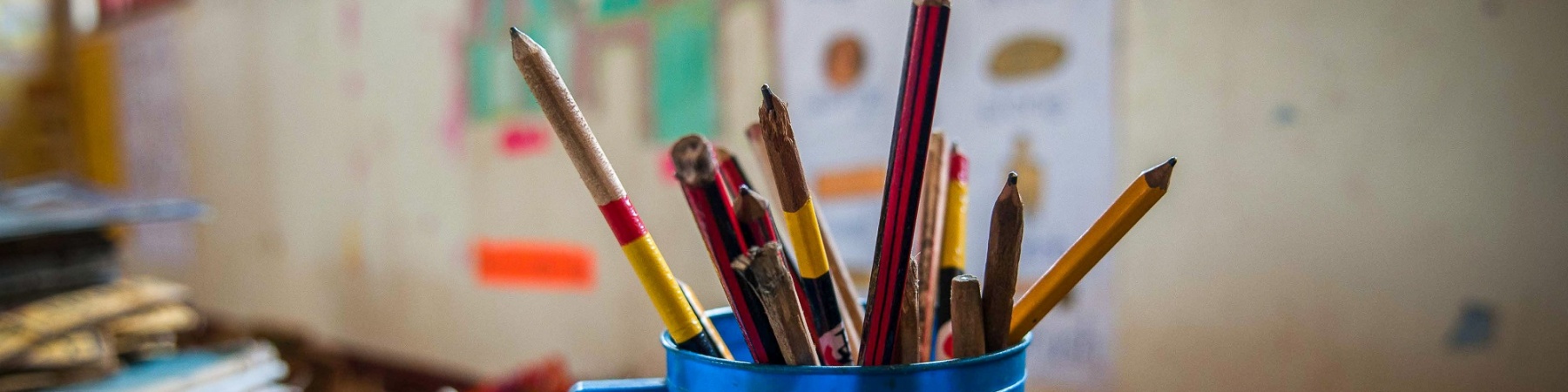 aula di scuola, foto a tazza blu piena di matite colorate