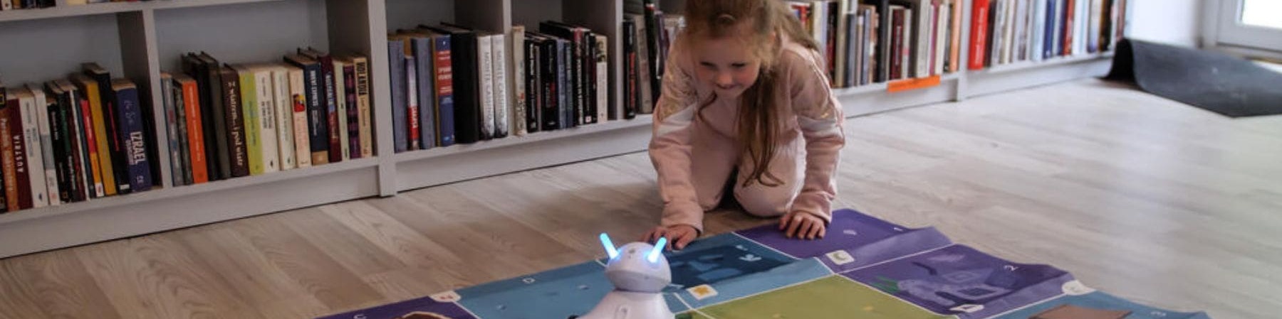 gioco stem per bambina che gioca con robot su un tappeto 
