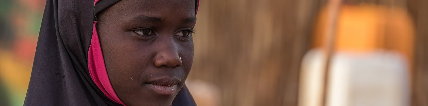Primo piano di profilo di una bambina africana che indossa un hijab rosa e nero
