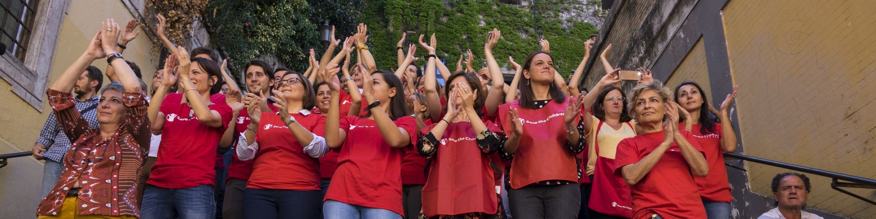 staff di save the children Italia applaude ai ragazzi che manifestano per il Global Strike fo Future, insieme a loro 4 bambini che applaudono sorridenti.