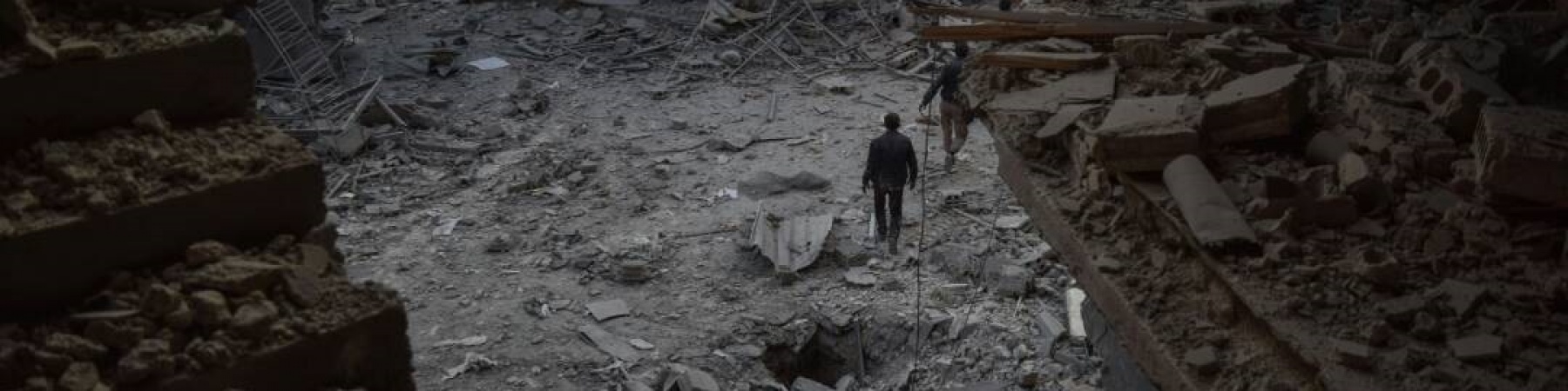 foto dall alto di un quartiere in Siria bombardato, nel sentro un uomo che cammina