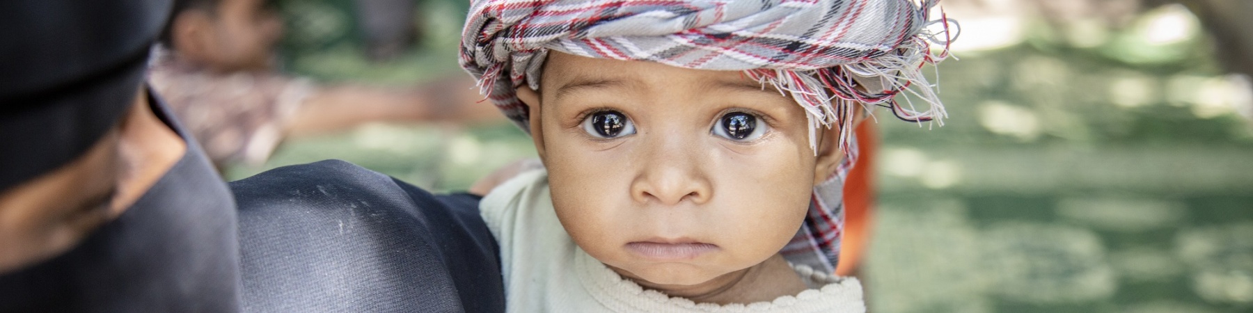 Guerra in Yemen bambino dello yemen con kefiah in testa in braccio alla mamma