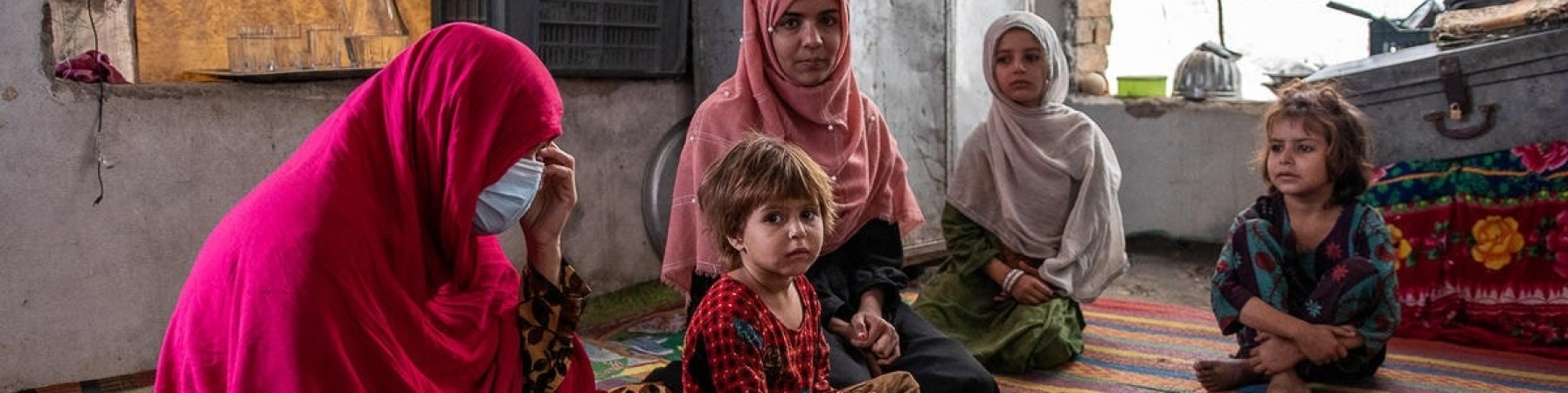 bambini afghani seduti su una stuoia
