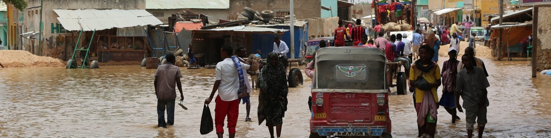 Popolazione somala sfollata a causa delle alluvioni cammina in acqua fangosa