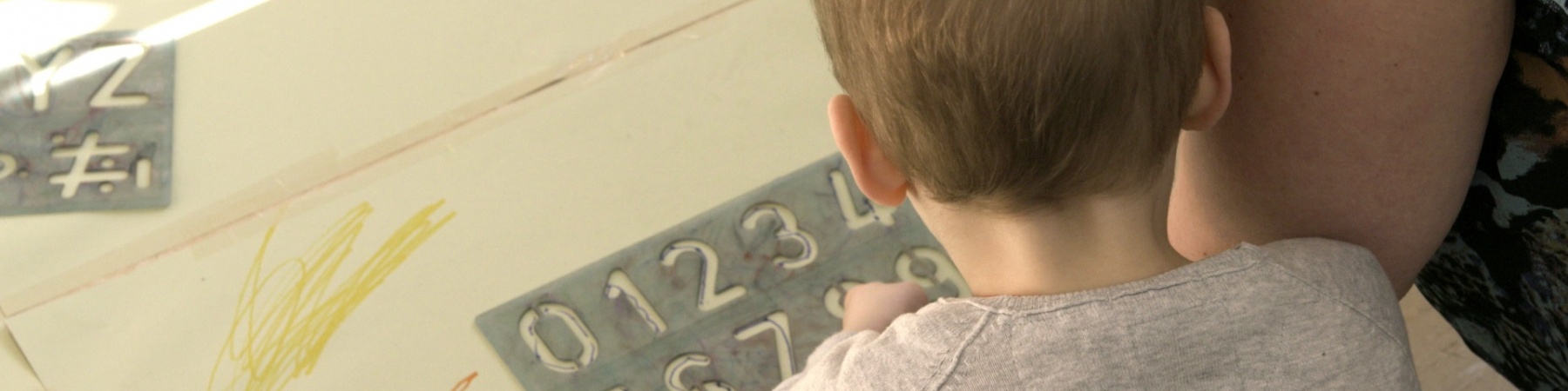 Intelligenza Numerica bimbo di spalle mentre gioca con la mamma a un gioco con i numeri