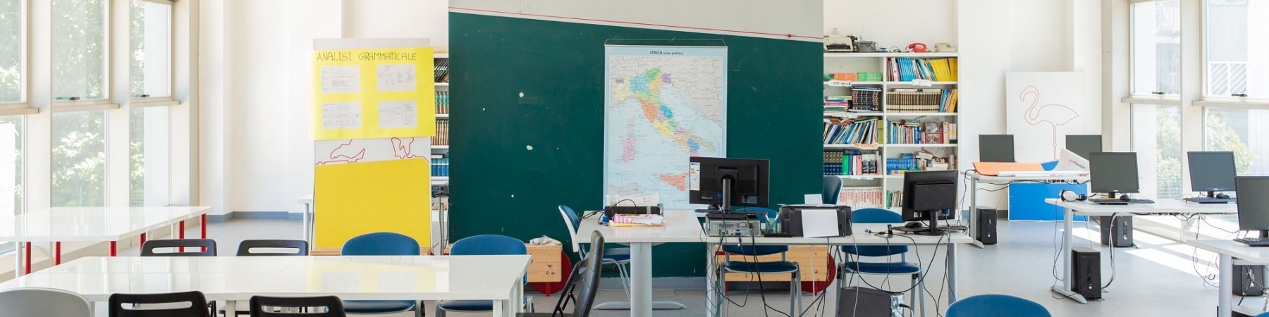 aula studio con banchi e sedie bianchi con lavagna verde, vuota senza bambini e bambine