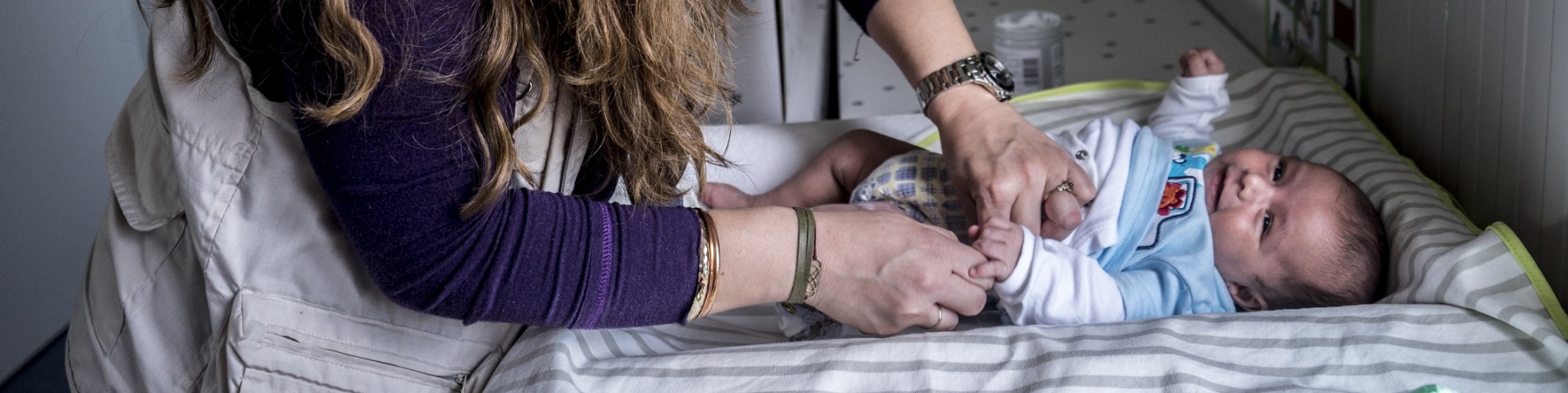 Mamma cambia pannolino a bambino su fasciatoio