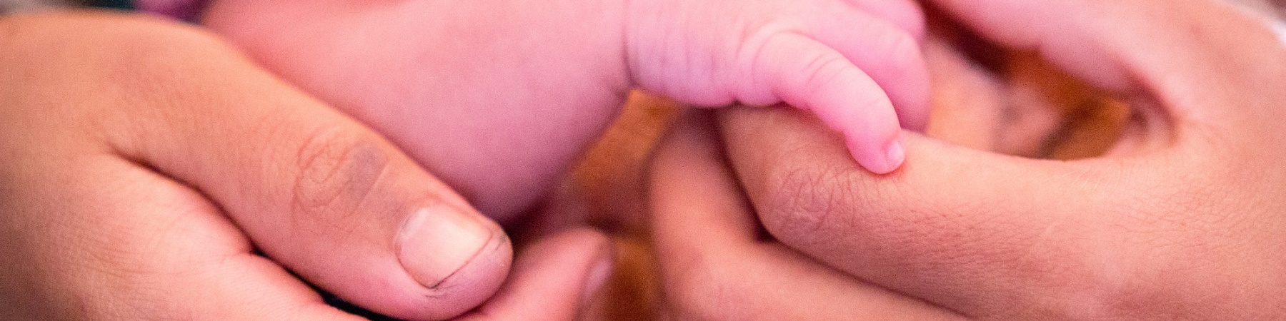 Mani di una mamma tengono la mano di suo figlio neonato