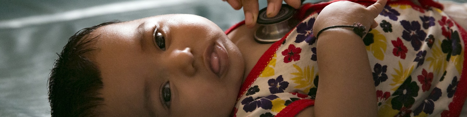 Bambina neonata Rohingya viene visitata stesa con stetoscopio.