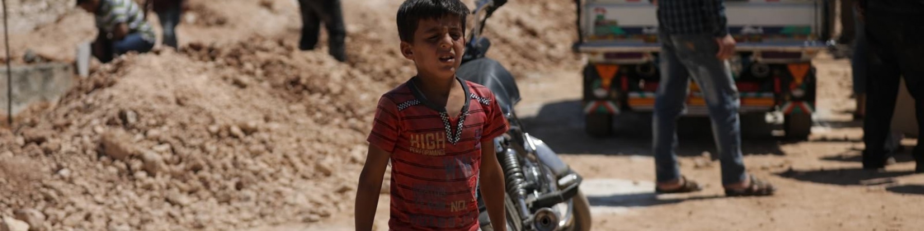 bambino siriano trasporta due taniche di acqua