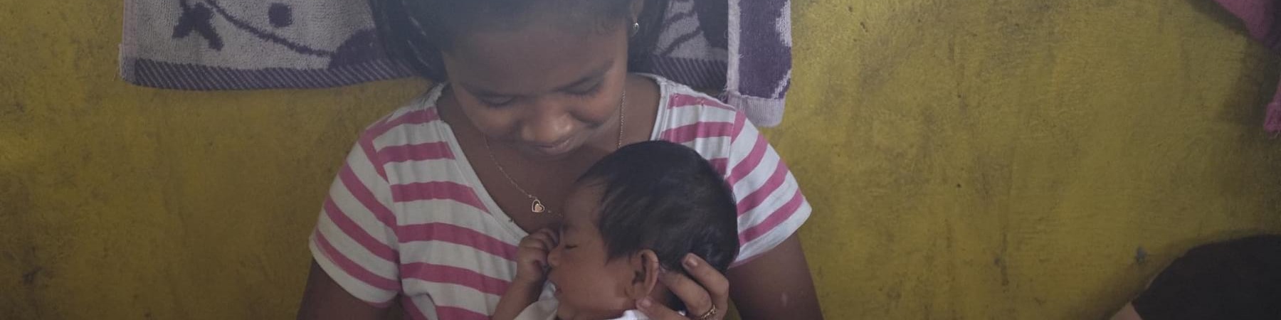 ragazza filippina sfollata tiene in braccio neonato