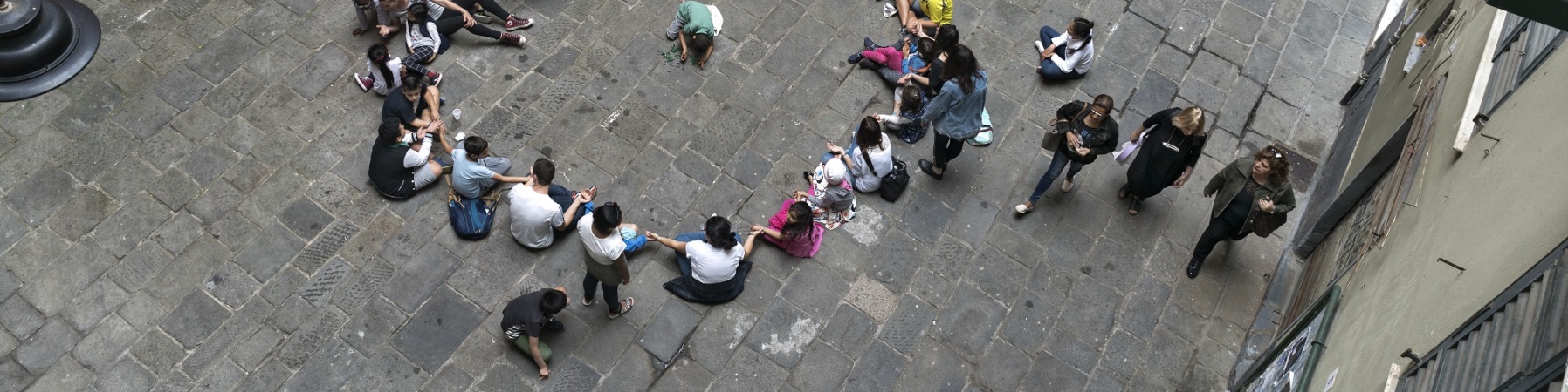 Foto dall'alto di bambini seduti in cerchio in un cortile scolastico