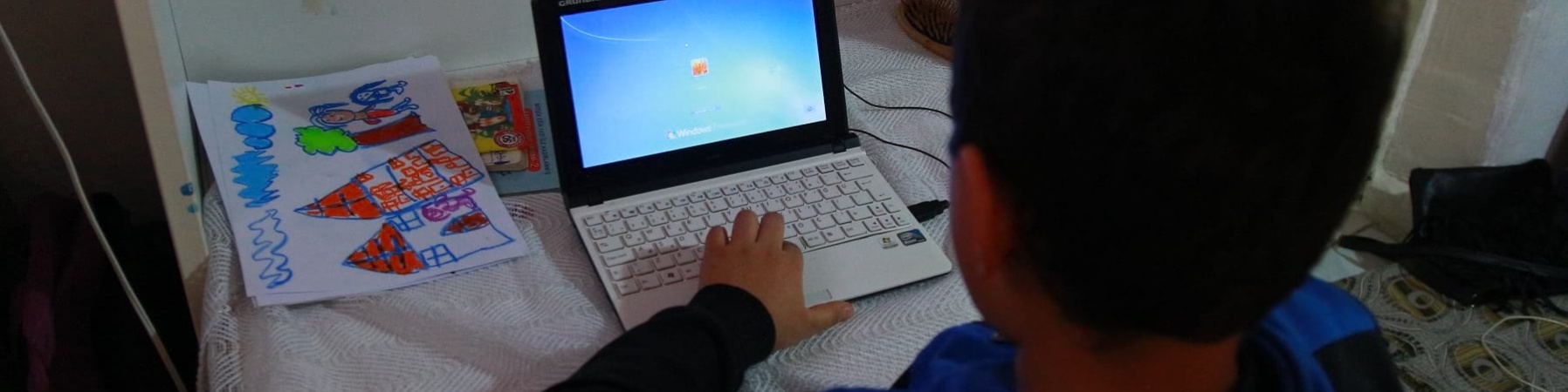 bambino-di-spalle-seduto-davanti-al-computer