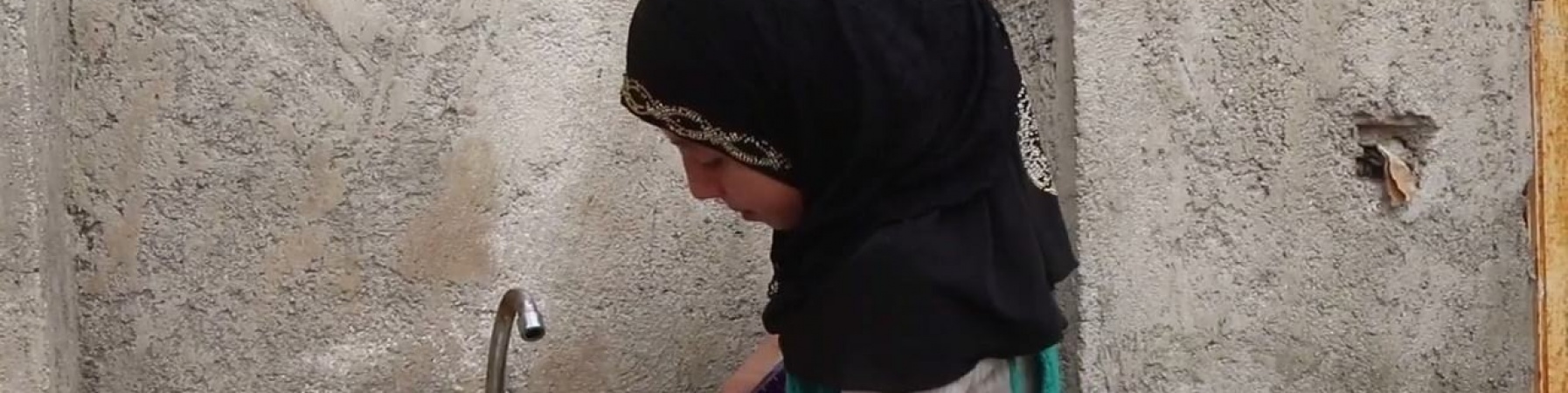 Bambina siriana di profilo vera il sapone sulle mani prima di lavarle al lavandino di fronte a lei.